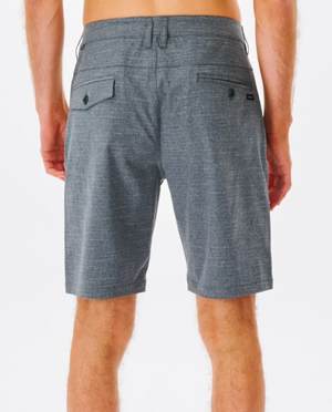 A person is seen from the back, wearing Rip Curl Boardwalk Epic Mix Shorts in gray, made of stretch recycled polyester for quick-dry comfort. The shorts have two hip pockets with button details. The plain white background accentuates the person's relaxed pose with hands by their sides.