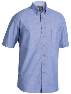 The Bisley Chambray Cotton Short Sleeve Shirt features a traditional fit, short sleeves, and a light blue color. It includes a collar and two button-secured front pockets. Crafted from cotton chambray, the casual design is enhanced by its brown buttons.