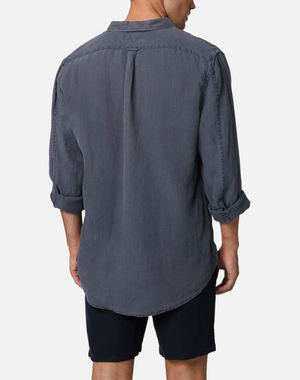 Wearing the Industrie The Tennyson Linen Shirt in relaxed fit and long-sleeve, rolled up sleeves in dark gray, paired with dark shorts. The image captures the back view against a white background, highlighting the 100% linen fabric.