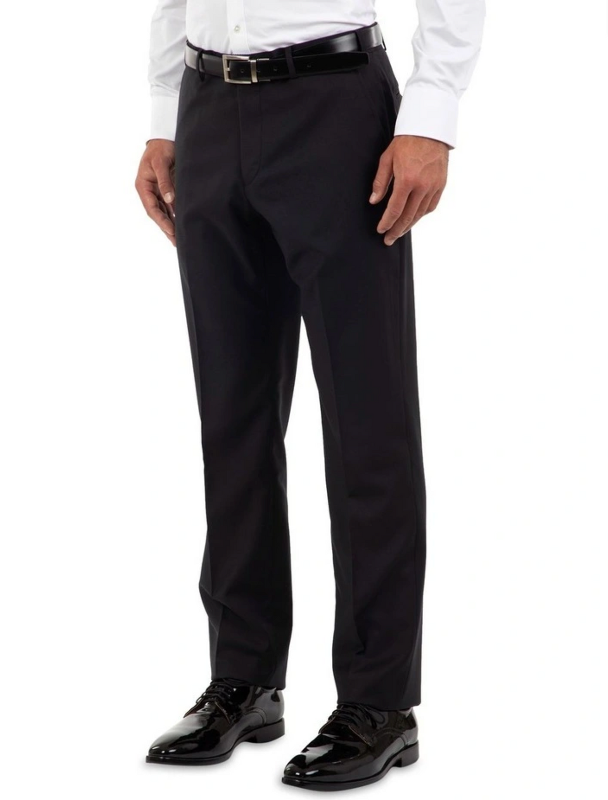 Wearing tailored fit black dress pants, a white long-sleeve shirt, and shiny black dress shoes, the person's hands rest by their sides, emphasizing the elegance. The Cambridge Jura Trouser enhances the ensemble's formal appeal seamlessly.