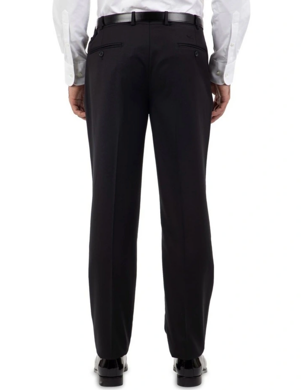 A person in black Cambridge Jura Trousers, paired with a white shirt and polished black shoes, is seen from the back. The tailored-fit pants feature buttoned back pockets and are held with a sleek black belt, as the individual stands upright facing away from the camera.