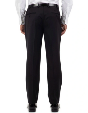 A person in black Cambridge Jura Trousers, paired with a white shirt and polished black shoes, is seen from the back. The tailored-fit pants feature buttoned back pockets and are held with a sleek black belt, as the individual stands upright facing away from the camera.
