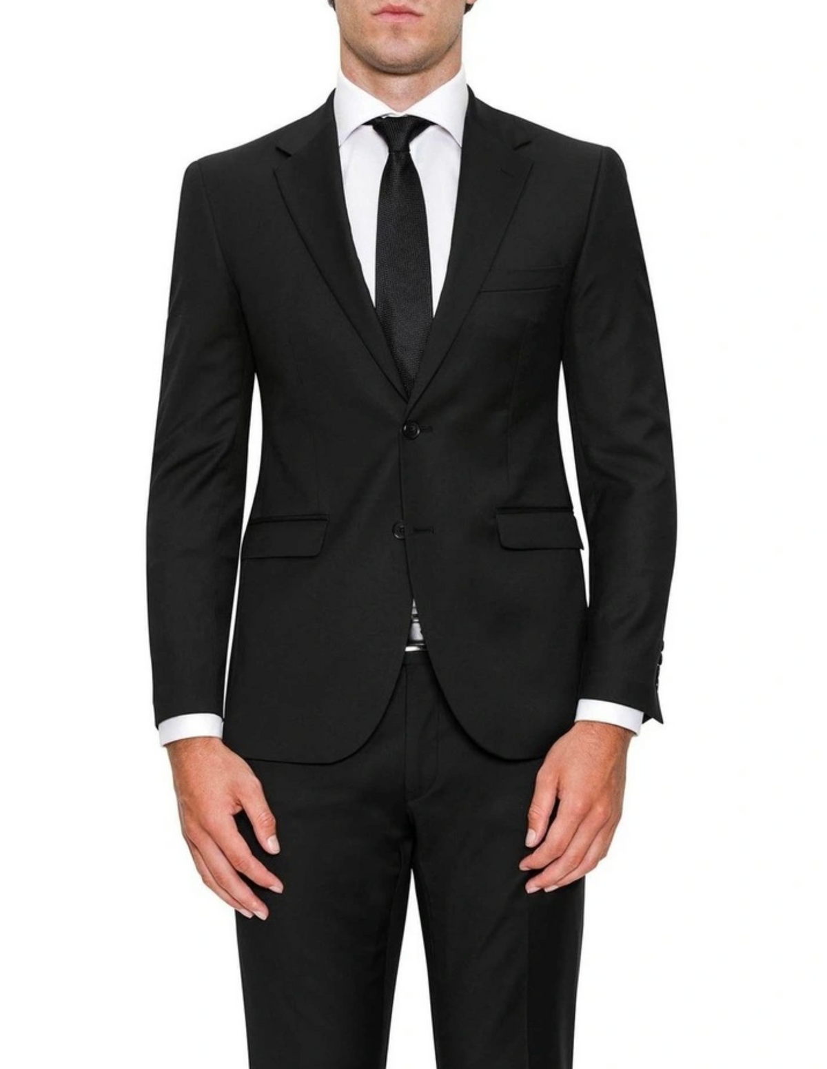 A man dressed in a Cambridge Serra Jacket, classic black suit with a tailored fit, complementing a white dress shirt and black tie. The suit jacket features a notch lapel. His hands rest relaxed at his sides against a plain white background.