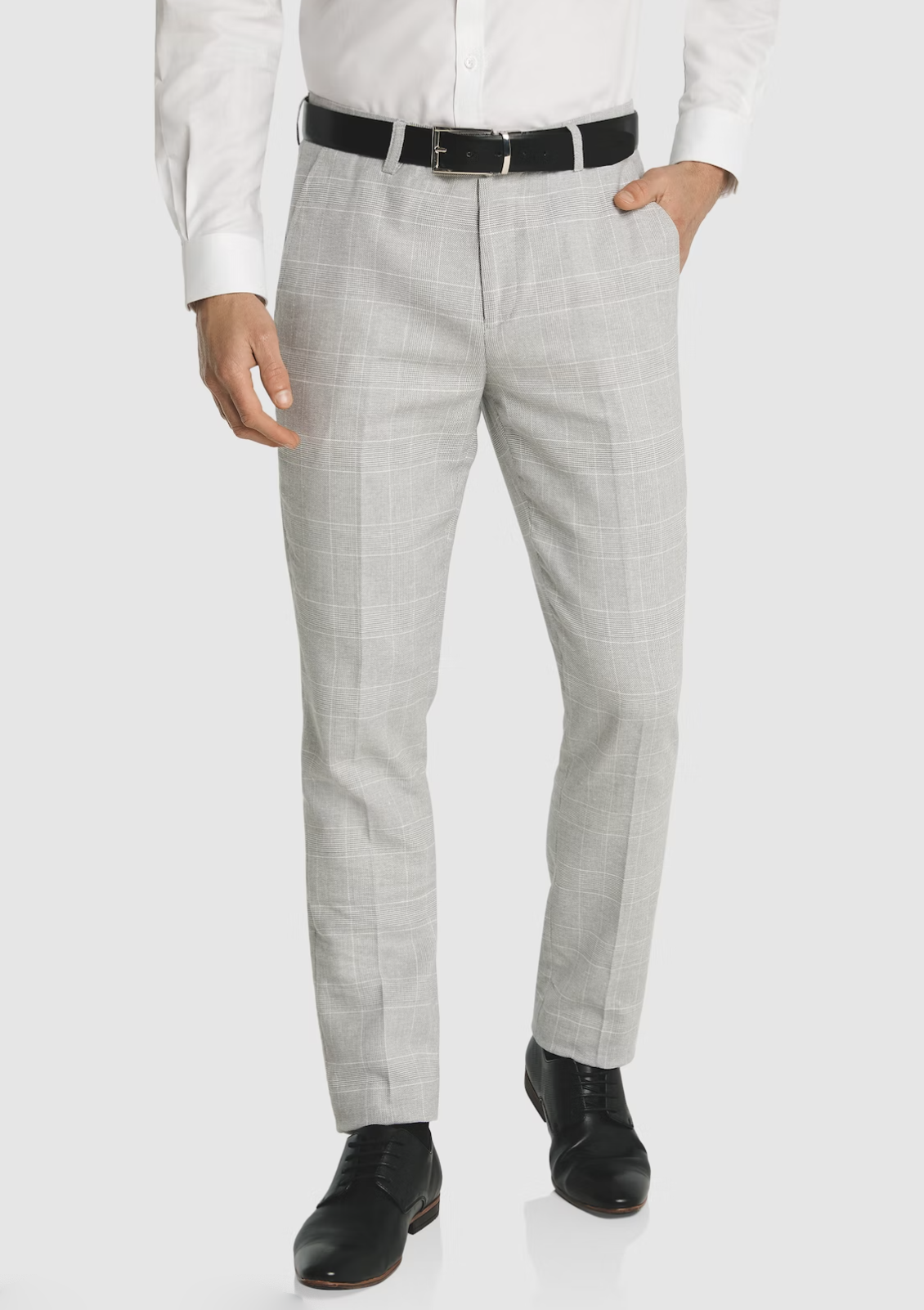 A man wearing Connor Sorrento Slim Dress Pant in light gray plaid, a white dress shirt, black belt, and black dress shoes is shown from the shoulders down against a plain background.