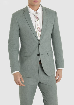 Connor stands against a plain white background, wearing the Connor Scarborough Slim Blazer in light gray, paired with a white dress shirt and a floral-patterned tie.