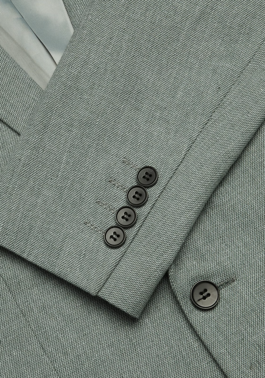 Close-up of the Connor Scarborough Slim Blazer sleeve, showing four black buttons and textured fabric, with part of the front and inside lining also visible.