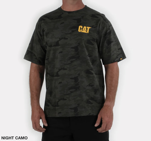A person wearing the CAT Trademark Tee, a 100% cotton casual shirt in dark green and black camouflage with a yellow "CAT" logo on the upper left chest. The "NIGHT CAMO" text decorates the bottom left corner against a white background.