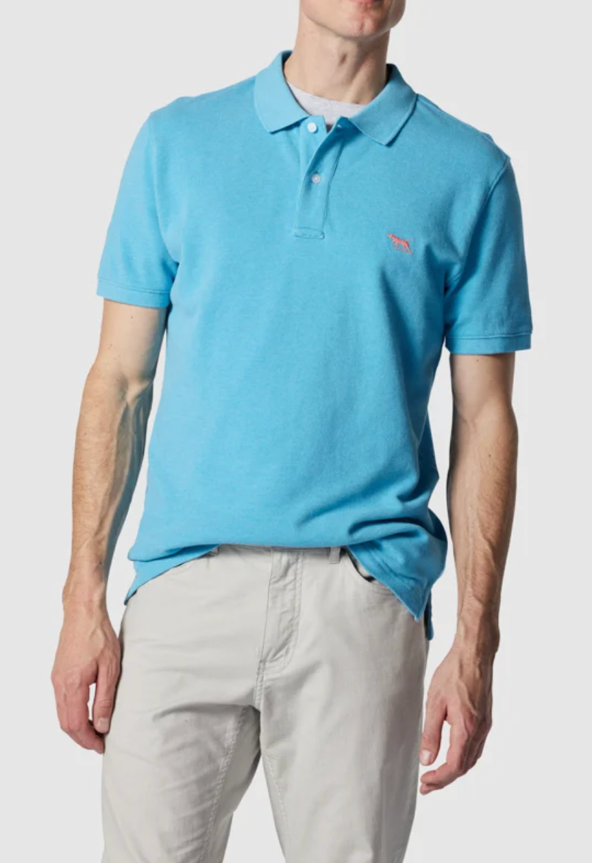 A person is wearing a light blue Rodd & Gunn The Gunn Polo made from Australian Cotton, modern fit, tucked into beige pants. Their arms rest relaxed at their sides against a neutral background.