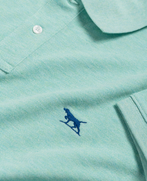 A close-up of the Rodd & Gunn The Gunn Polo in light green, made from premium Australian Cotton, displays a small blue embroidered kangaroo logo near the bottom. This modern-fit polo features textured fabric and a visible white button at the top.