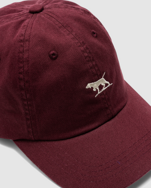 A maroon Rodd & Gunn Gunn Cap made of durable cotton twill with a white embroidered dog on the front against a plain backdrop.