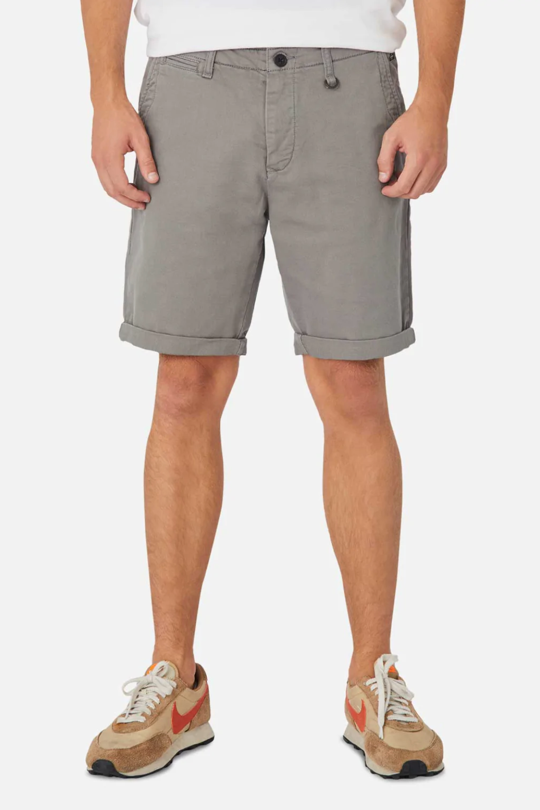 A person wearing Industrie The Rinse Drifter Short paired with a white cotton shirt and beige sneakers with red accents, stands against a plain white background showcasing their legs and lower torso.