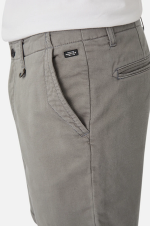 A close-up showcases a person wearing Industrie The Rinse Drifter Short, light gray cotton shorts paired with a white top. The relaxed fit features front pockets and a small sewn label near the waist, beautifully capturing the front side and upper section.