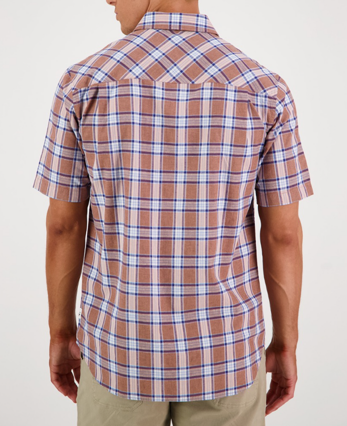 A person is seen from behind in a short-sleeved Swanndri Kennedy Point Shirt, featuring brown and blue plaid, a cotton-linen blend with collar and buttons. They wear light-colored pants against a plain white background, highlighting the shirt's tailored fit.