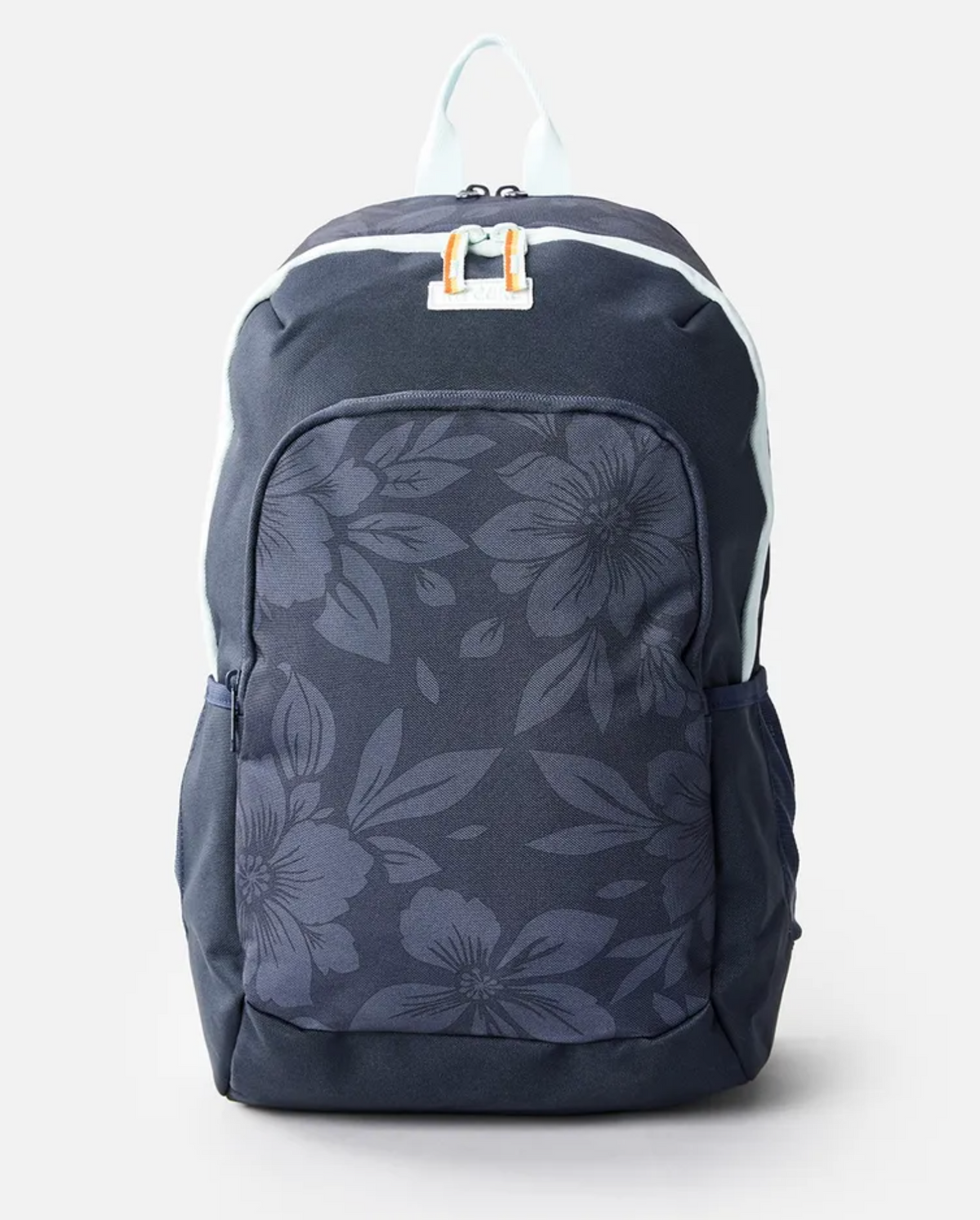 The Rip Curl Heat Wave Ozone 30L Backpack is a dark blue, laptop-compatible bag with a floral-patterned front pocket. Made from recycled polyester, it boasts white zippers, side pockets, and a light blue handle on a plain light gray background.