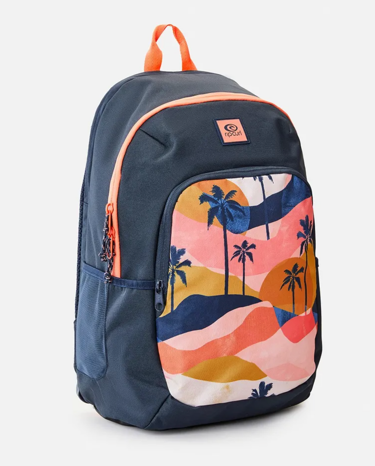 The Rip Curl Ozone 2.0 30L Backpack, made from recycled polyester, showcases a navy blue design with orange zippers and handle. A sunset-patterned front pocket with palm trees complements its roomy interior, perfect for a secure fit of a 15" laptop.