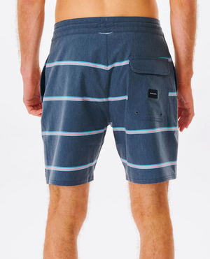 Someone showcases the Rip Curl Monarch Layday boardshorts in blue with white stripes and a back pocket highlighted by a small rectangular black tag, crafted from quick-drying recycled PET fabric, set against a plain white background.