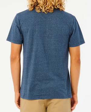 Rear view of a person with long, curly blonde hair wearing a blue Rip Curl Established Tee in a comfortable Cotton/Polyester blend and beige pants, against a plain white background.