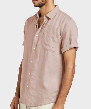 Man wearing the Academy Brand Hampton Linen Short Sleeve Shirt in light pink, featuring a regular fit, point collar, chest pocket, and rolled sleeves, standing against a plain background.