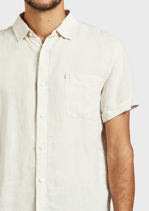 A man wears the Academy Brand Hampton Linen Short Sleeve Shirt in off-white, regular fit, with a chest pocket, shown from shoulders to waist against a plain background.