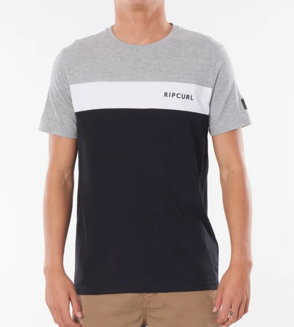 Wearing the Rip Curl Undertow Panel Tee with a light gray top, a white "RIPCURL" stripe, and a black bottom creates an effortlessly stylish look when paired with beige pants.