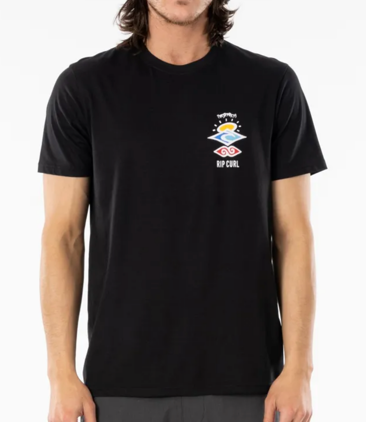 The individual models a black Rip Curl Search Icon Tee, crafted from organic cotton. It features a vibrant abstract design of orange, yellow, and pink waves beneath a sun, set against a plain white backdrop.