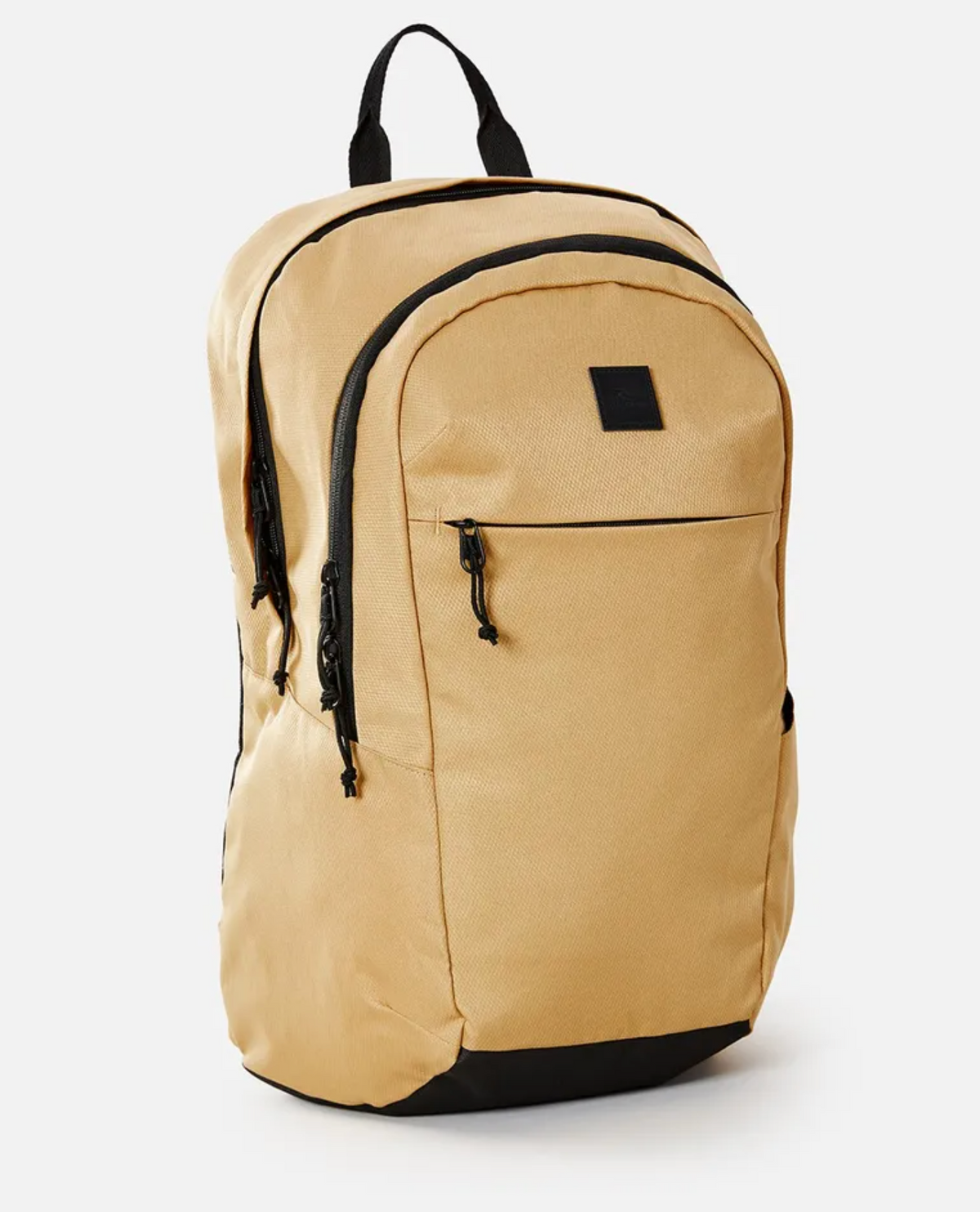 The Rip Curl Overtime 30L Overland Backpack is crafted from recycled polyester in tan with black accents and zipper. It features a front pocket, a small rectangular logo patch, carrying handle, dual shoulder straps, and fits a 15" laptop for all your travel needs.