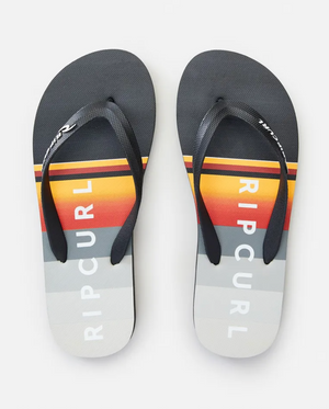 The Rip Curl Daybreak Thongs feature ergonomic molded rubber straps and premium EVA rubber footbeds. The footbeds display a gradient striped pattern in black, yellow, red, and various shades of grey, with "RIP CURL" prominently printed in white.
