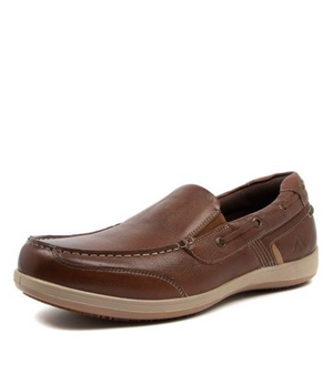 The Colorado Broad Slip On Boat Shoe is a brown leather loafer featuring visible stitching, eyelet accents, and a subtle logo near the heel. It includes a light beige sole, memory foam footbed for comfort, and a slip-resistant design ideal for all-day wear.