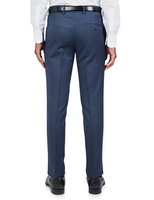 A person is seen from the back wearing Uberstone Joe Trousers, which are tailored dark blue, slim-fit dress pants made from a wool blend. They pair them with a white dress shirt, black belt, and black dress shoes against a plain white background.