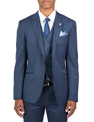 Someone is dressed in a tailored blue Uberstone Troy Jacket three-piece suit with a slim fit, shirt, and tie. The outfit includes a matching pocket square and small lapel pin on the jacket's notch lapel, all set against a plain white background.