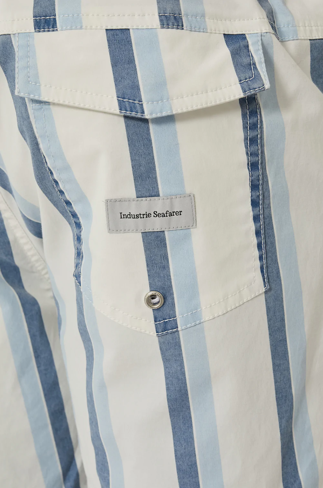 Close-up of a shirt pocket with blue and white vertical stripes, featuring Industrie branding. A button secures the flap, with a "Industrie Seafarer" label. Product: Industrie The Rubio Bahama Short.