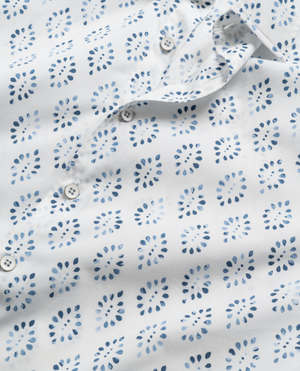 Close-up of a Rodd & Gunn Penguin Place Sports Fit Shirt showcasing blue dot clusters in a grid pattern on 100% cotton fabric. It features small white buttons down the front.