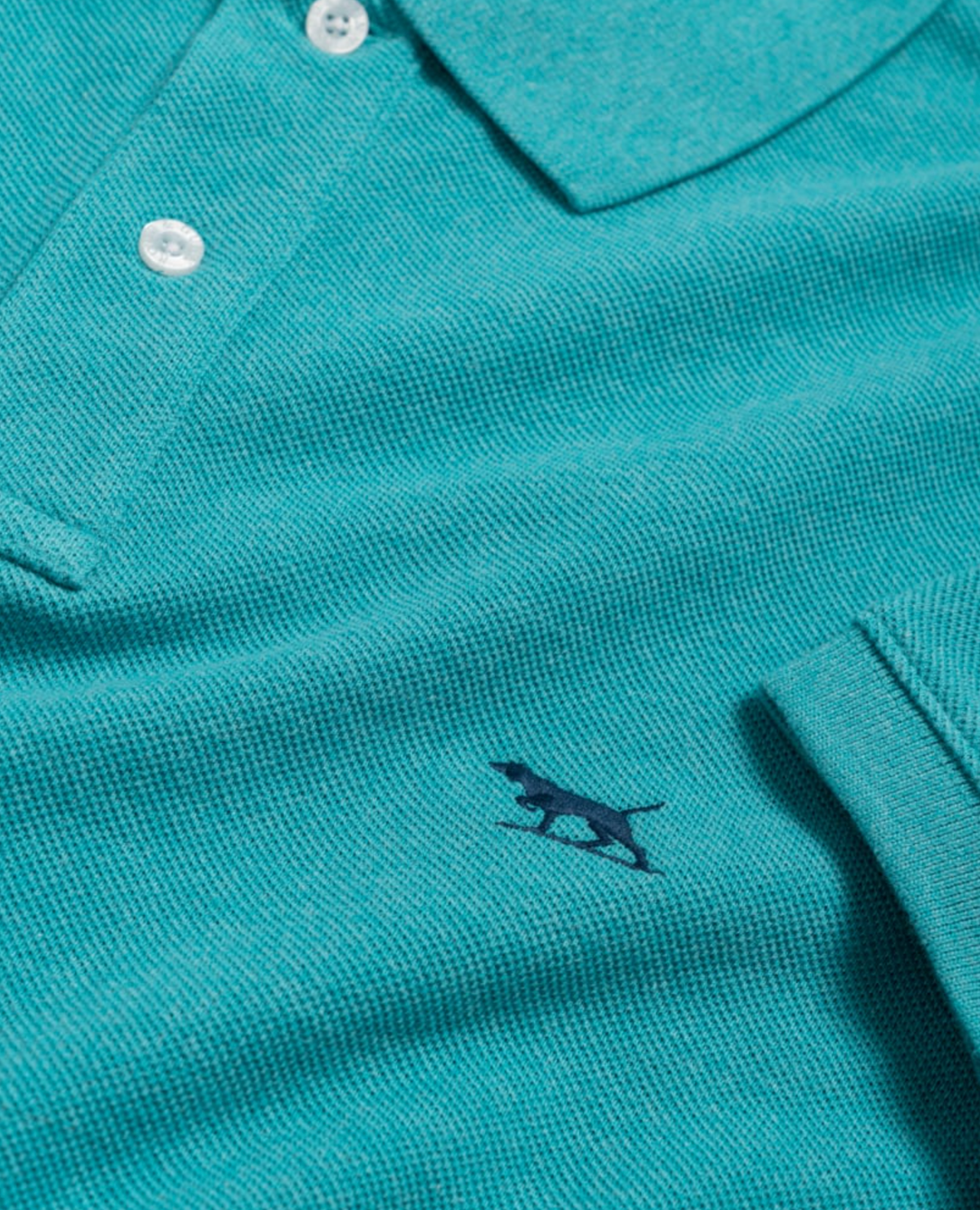 The Rodd & Gunn The Gunn Polo is crafted from premium Australian cotton and features a modern fit in striking turquoise with white buttons, accented by a dark blue embroidered dog logo.