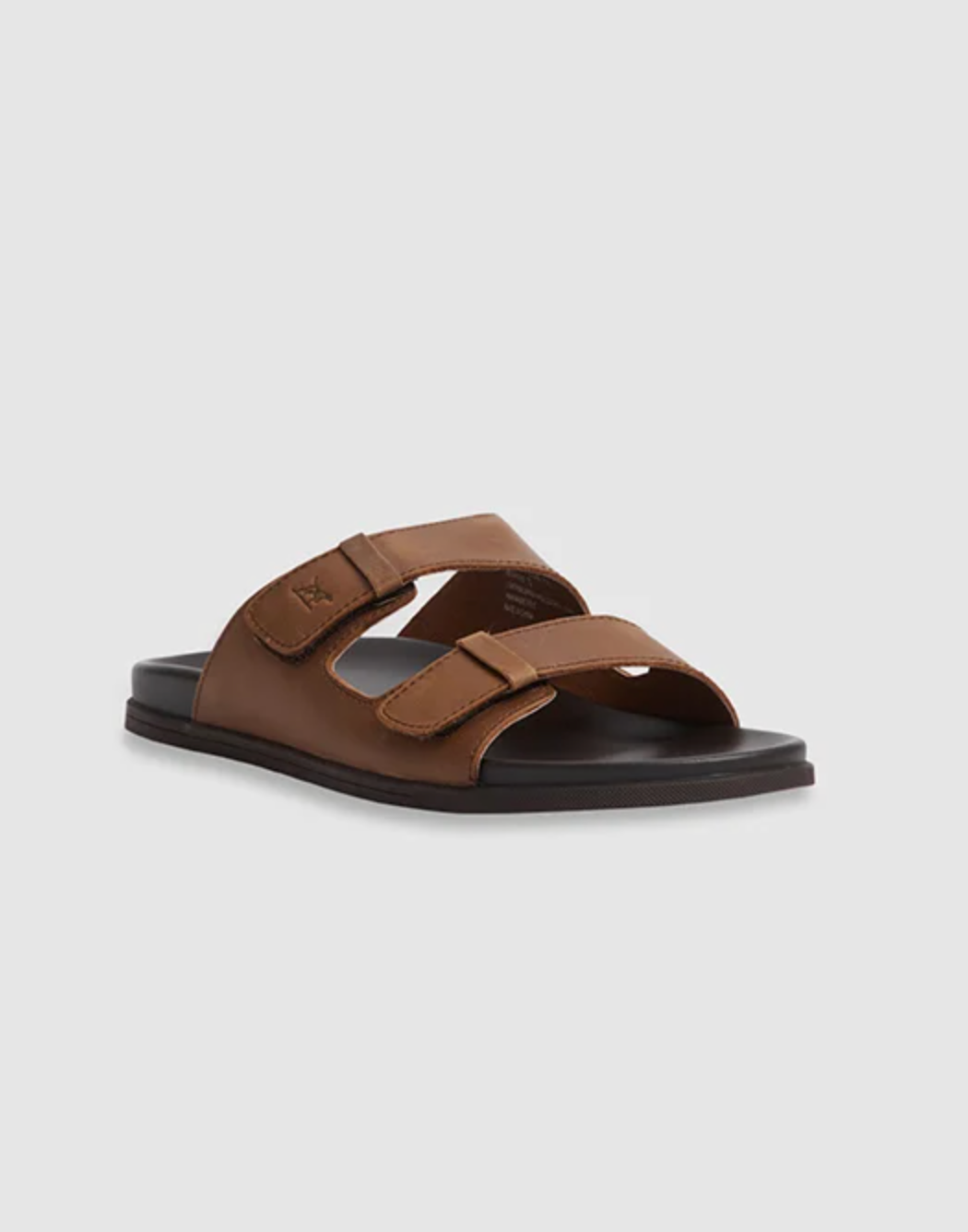 The Rodd & Gunn Kendrick Place Slide, featuring brown leather straps and a flexible rubber sole, is displayed against a plain gray background.