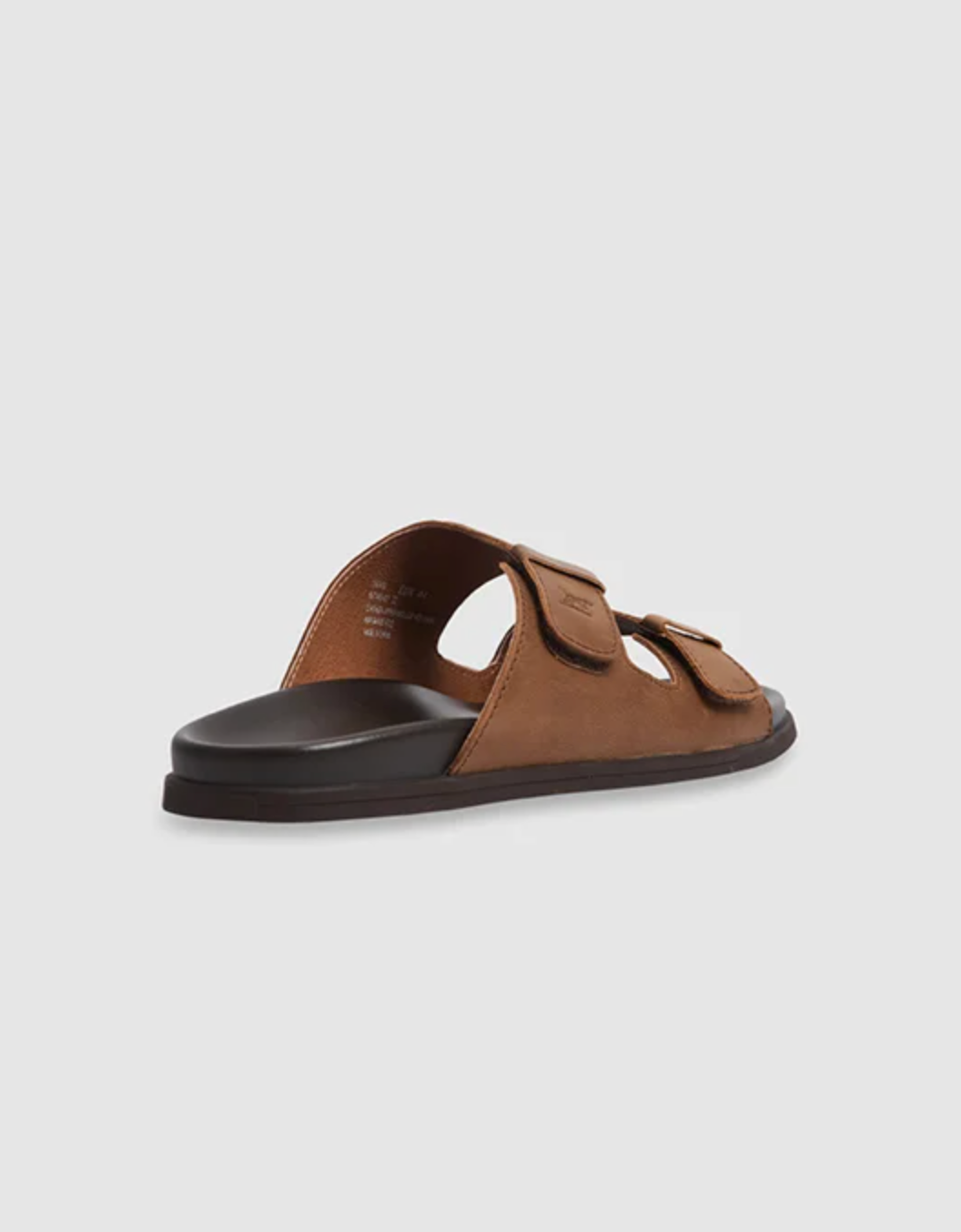 The Rodd & Gunn Kendrick Place Slide is a brown sandal with leather straps, two adjustable fastenings, and a flexible rubber sole on a black base, showcased from the back on a plain white background.