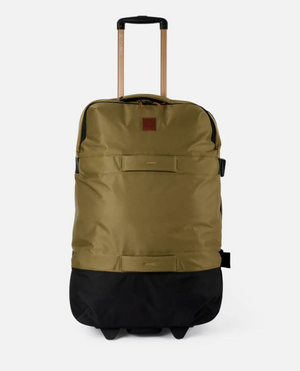 The Rip Curl F-Light Global 110L Overland Travel Bag, crafted from recycled polyester in khaki and black, includes a rectangular leather patch on the front with zippered compartments. It features an extendable handle and durable wheels, making it perfect for any journey.