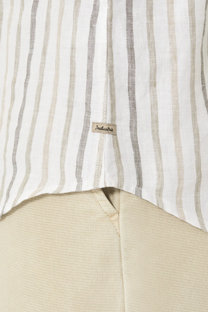 Close-up of the beige and white striped "Industrie The Webster Long Sleeve Shirt" with a tag reading "Industrie." The relaxed-fit shirt overlaps beige pants, showcasing the texture and pattern contrast.