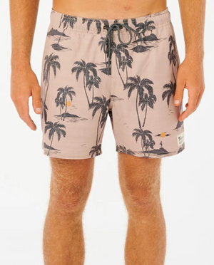A person in Rip Curl Mod Tropics Volley shorts, light brown with a black palm tree pattern, featuring quick-dry fabric, drawstring waist, and a small logo patch near the hem. They have light skin against a plain white background.