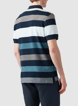 Someone wearing a Rodd & Gunn Lake Hayes Polo made from premium Australian cotton, showcasing a sports fit with navy, light blue, white, and gray horizontal stripes. They face away from the camera against a plain light gray background and pair it stylishly with dark pants.
