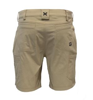 Timberland Pro Tempe Shorts in beige with multiple pockets and belt loops. They feature a small "PG" logo patch on the front and an "X" logo on the waistband. These moisture-wicking utility shorts are designed for practical wear.
