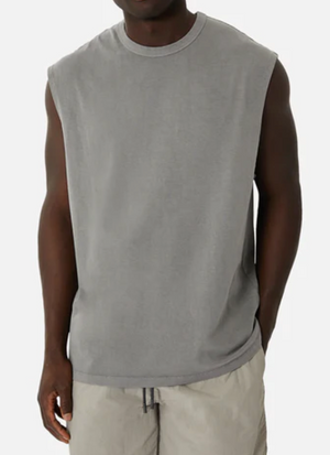 Dressed in an oversized Industrie The Del Sur Sleeveless Tee and light gray shorts, a person stands against a plain white background. Made from 100% cotton, the outfit offers a casual and comfortable vibe, with the individual's hands relaxed at their sides.