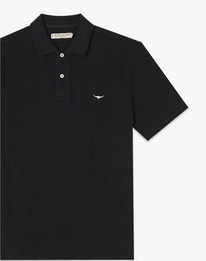 The RM Williams Rod Polo is a black cotton pique polo shirt equipped with a ribbed collar and short sleeves. It showcases two buttons at the top and a small white Longhorn embroidery on the left chest.