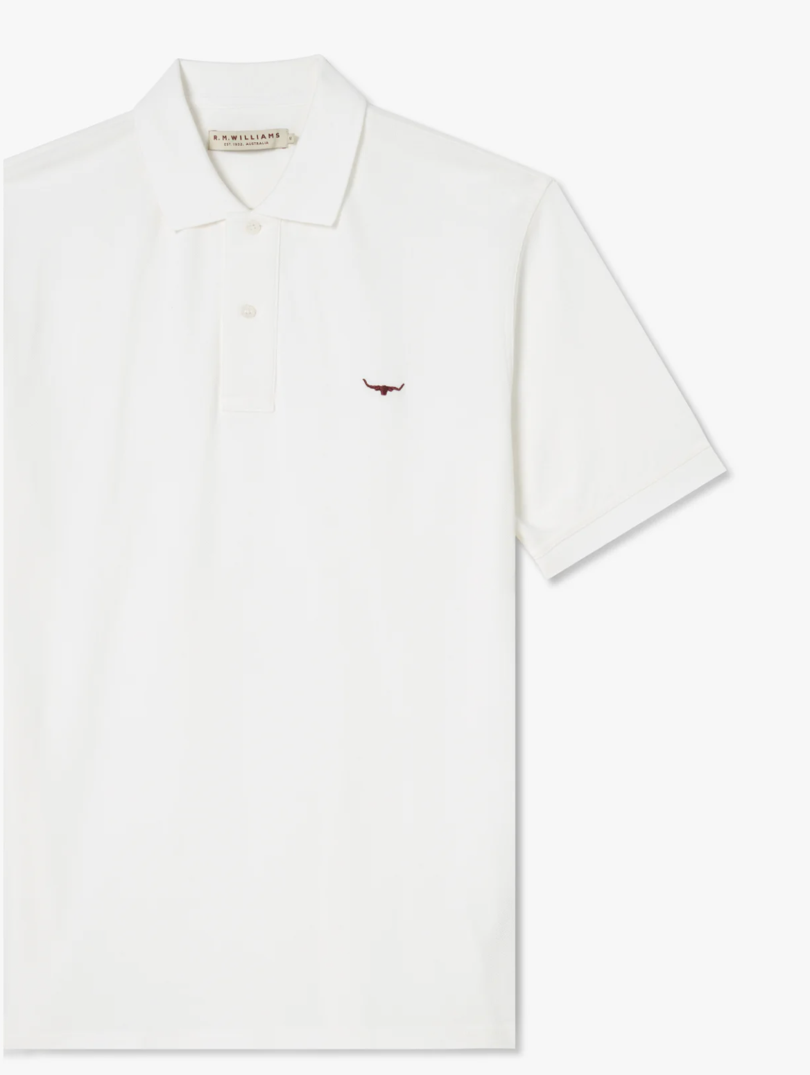 The RM Williams Rod Polo is a white short-sleeved cotton polo shirt, showcasing a small embroidered red Longhorn logo on the left chest. It features a classic collar and three-button placket, making it a casual wardrobe staple.