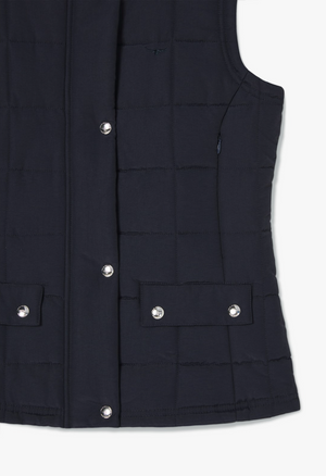 The RM Williams Wilpena Creek Vest is beautifully displayed against a white background, highlighting its quilted navy blue design with silver snap buttons down the front, two flap pockets with snap closures at the waist, and subtle horizontal stitching.