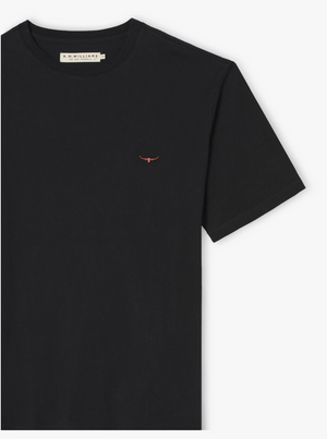 The RM Williams Parson T-Shirt is a classic piece in black, showcasing a small embroidered red bull symbol on the left side of the chest. Crafted from pure cotton jersey, it features a crew neck and short sleeves. The label inside the collar reads "R.M. Williams.