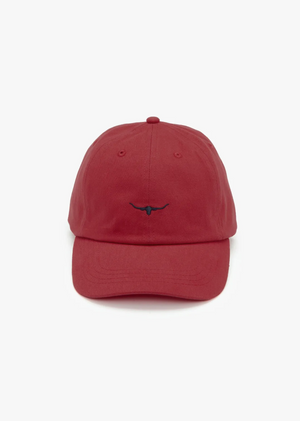 The RM Williams Mini Longhorn Cap is a classic red twill cap, showcasing a blue embroidered longhorn symbol on the front, set against a white background.
