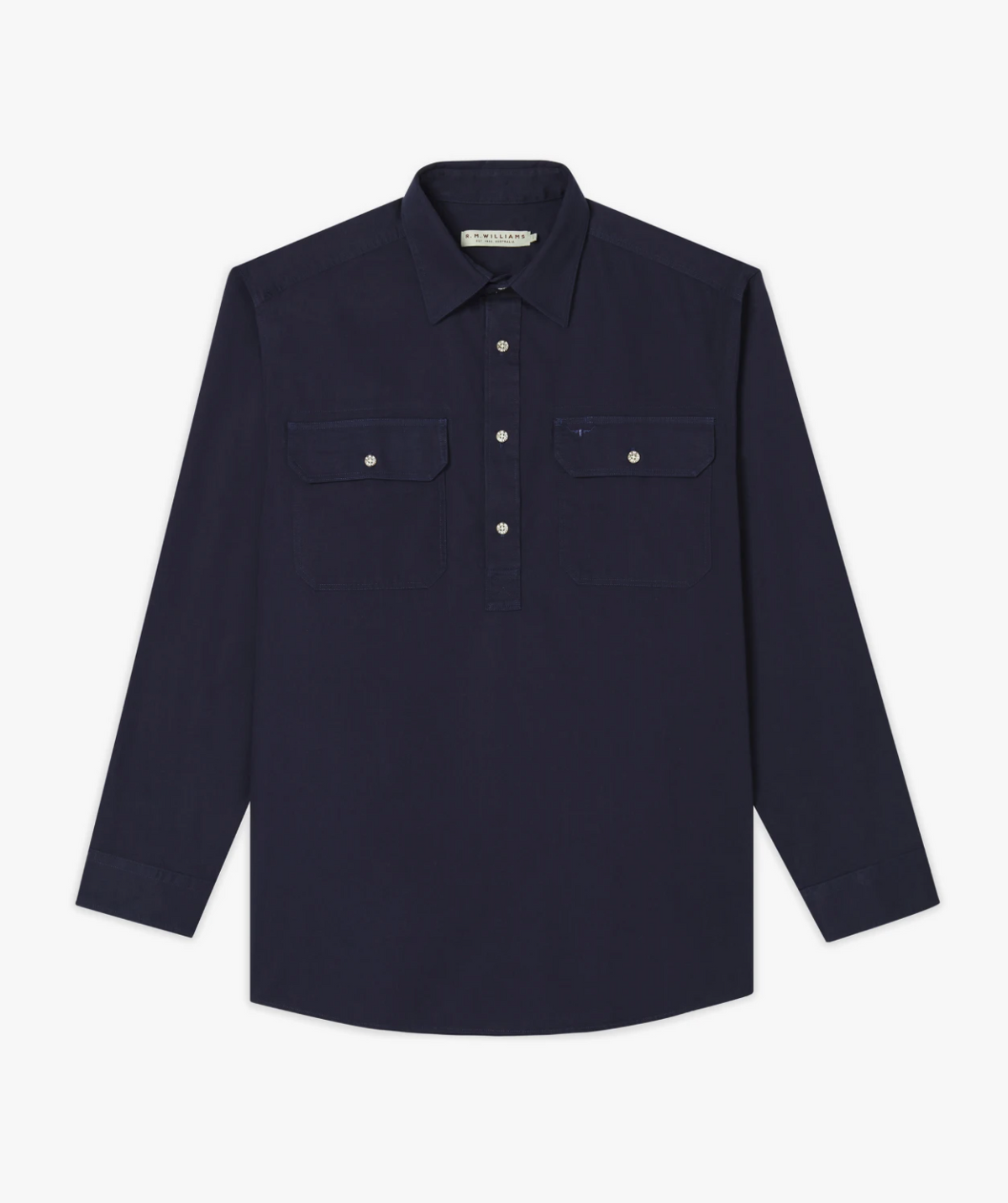 The RM Williams Angus Shirt is a relaxed fit, long-sleeve dark navy work shirt with a collar, partial button-up front, and two chest pockets with buttoned flaps, shown laid flat on a white background.