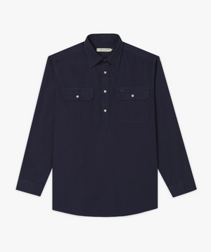 The RM Williams Angus Shirt is a relaxed fit, long-sleeve dark navy work shirt with a collar, partial button-up front, and two chest pockets with buttoned flaps, shown laid flat on a white background.