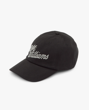 The RM Williams Script Cap is a black cotton twill cap with white cursive "McWilliams" embroidery. It features a curved brim, classic six-panel design, and an adjustable strap for a perfect fit.