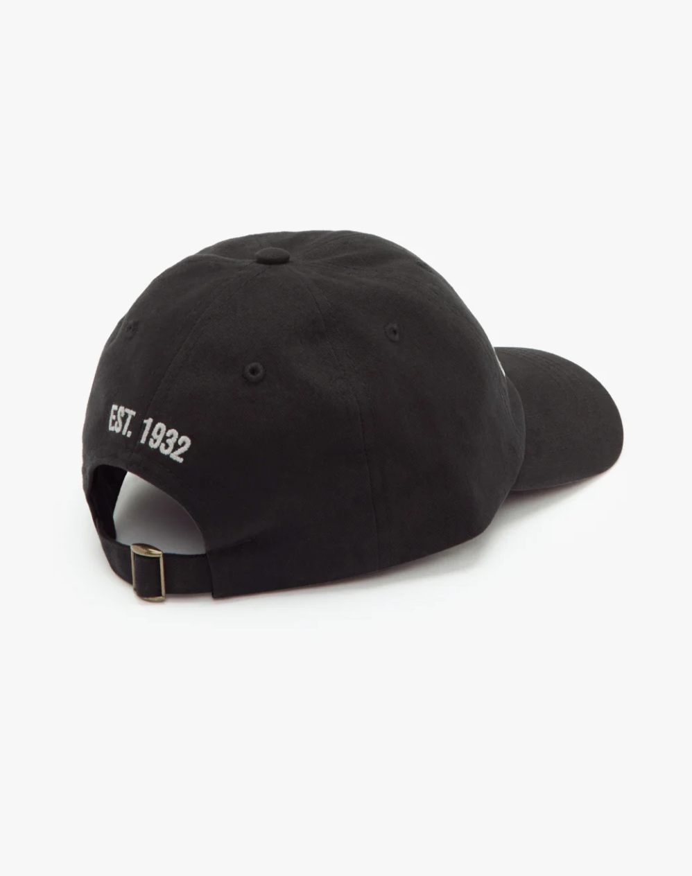 The RM Williams Script Cap in black has "Est. 1932" embroidered on the back in white, is crafted from cotton twill, and includes an adjustable strap with a metal buckle, presented on a white background.